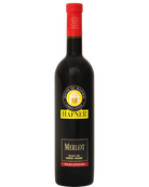 Hafner Merlot "L" 2024 Rotwein in einem Weinglas, dunkle rubinrote Farbe, elegante Flasche im Hintergrund